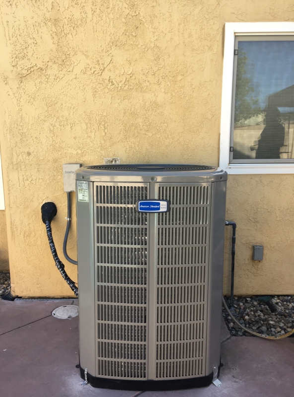 grey residential air conditioning unit installed in side of house in riverbank