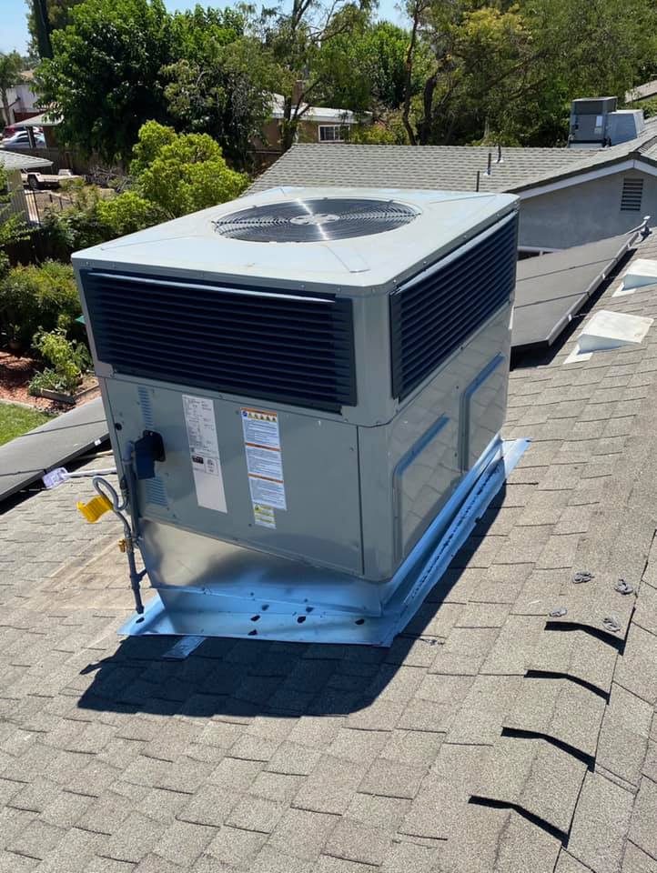 packaged air conditioning unit on top of a sloped composite roof