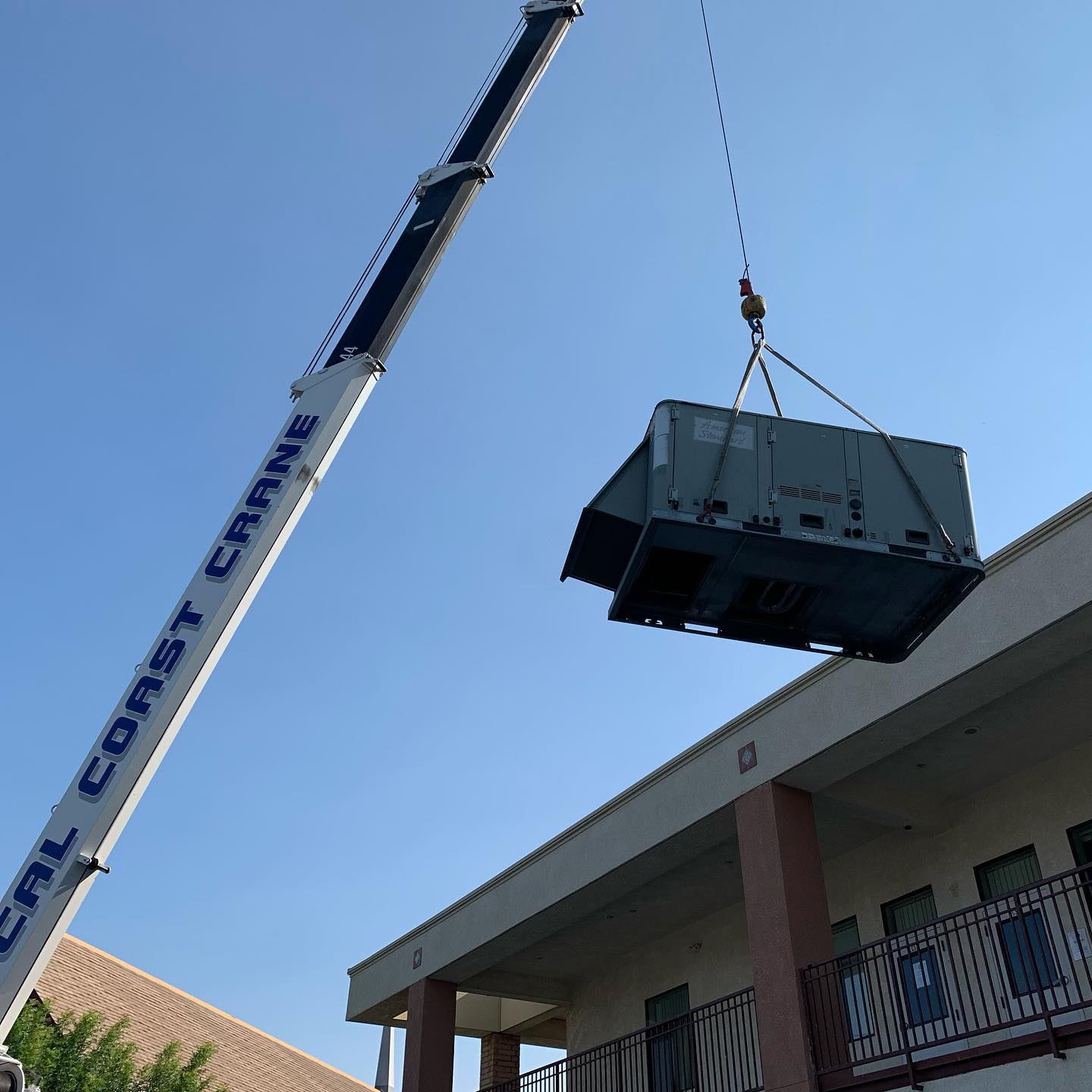 packaged commercial HVAC unit being lowered into place