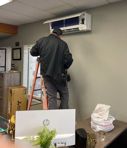 tech finishing an air conditioner installation